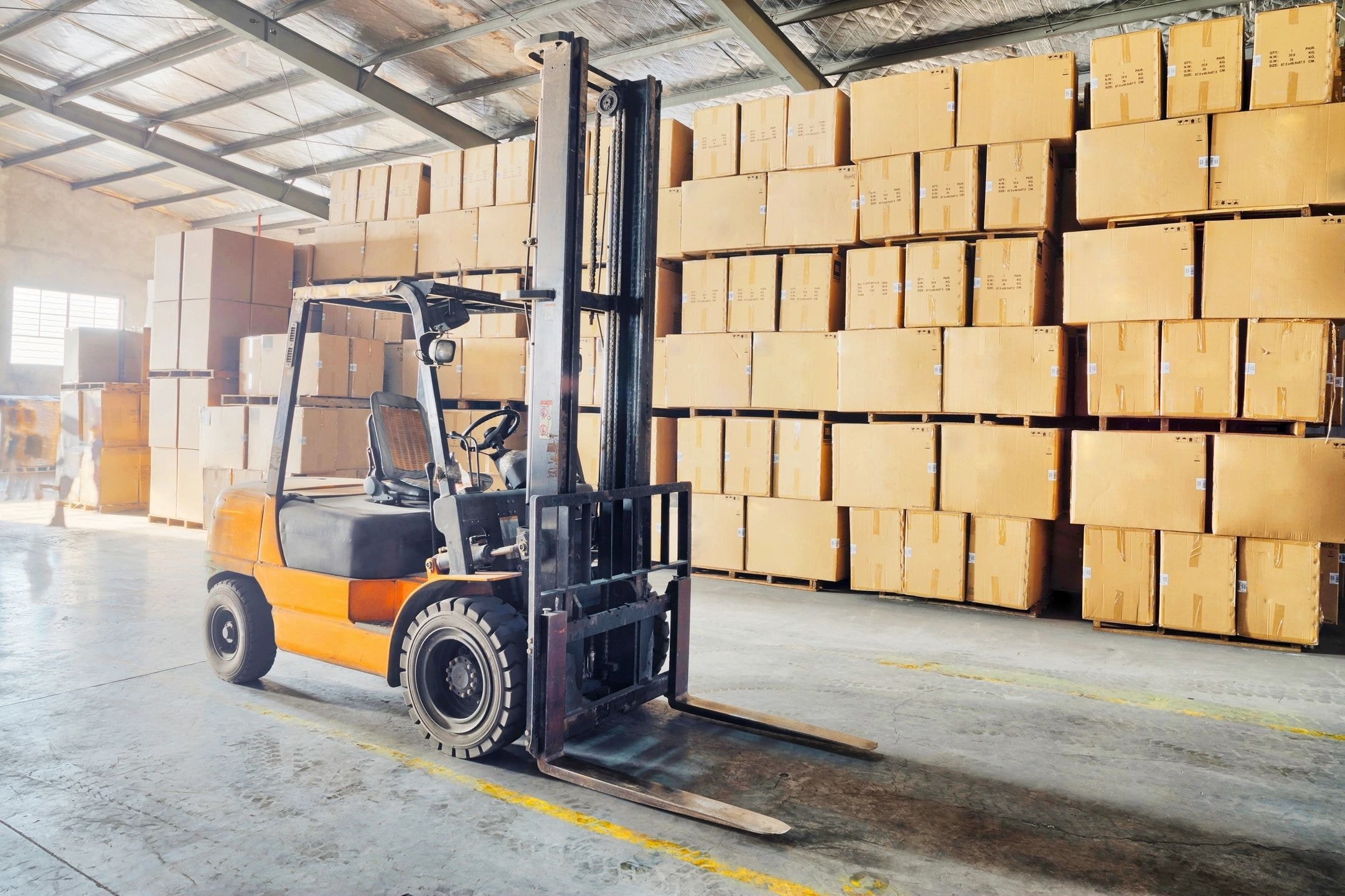 Interior de almacén con montacargas y cajas en estantes